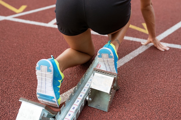 Foto gratuita donna all'angolo alto della linea di partenza in esecuzione