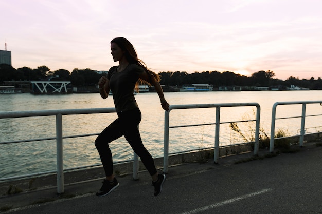 Woman running on street at sunset