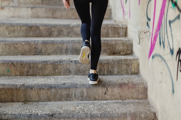 Free photo woman running up stairs outside