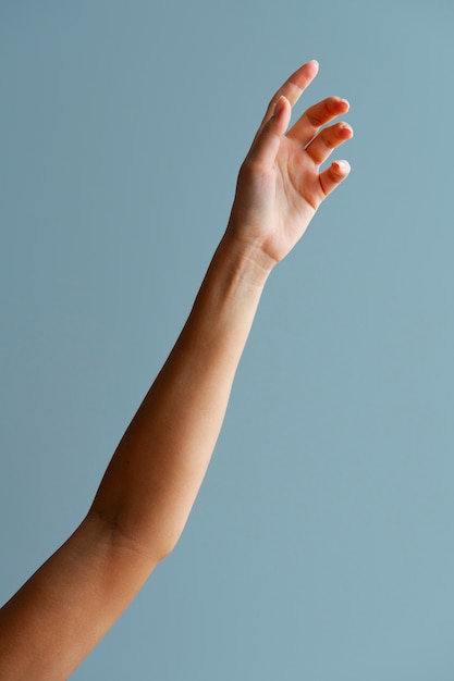 Woman's arm posing with blue background