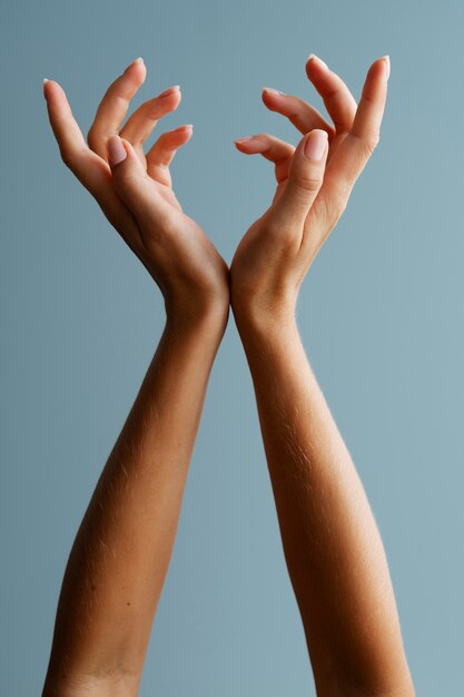 Руки женщины позируют на синем фоне