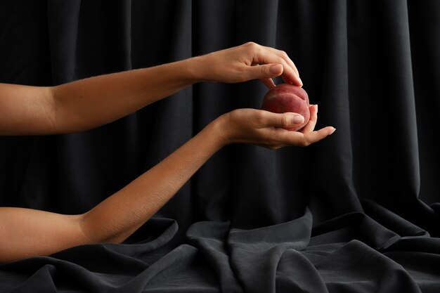 桃でポーズをとる女性の腕