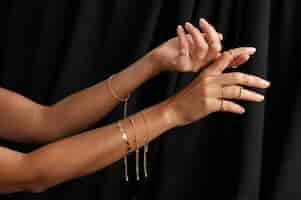 Free photo woman's arms wearing golden jewelry