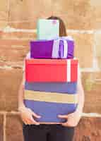 Free photo woman's face hidden by stacked gifts