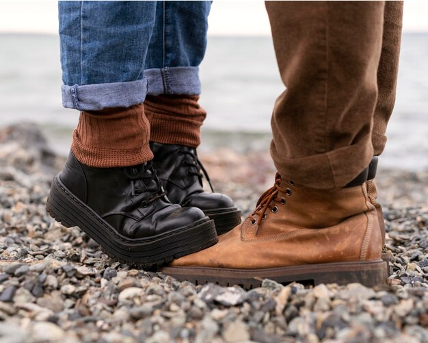 Woman's feet stepping on boyfriend's boots