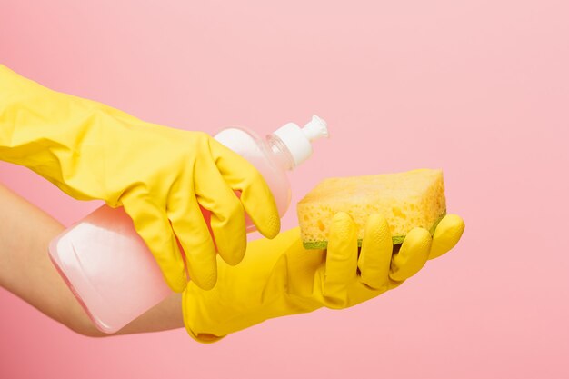 Чистка руки женщины на розовой стене. Концепция уборки или уборки