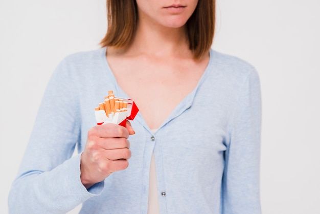 Woman's hand crushing packet of cigarette