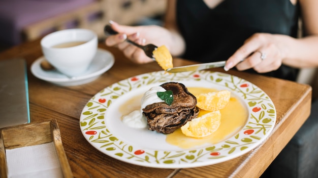 Foto gratuita la mano della donna che mangia la prima colazione nel caffè