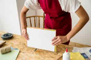 Free photo woman's hand holding mold over wooden desk