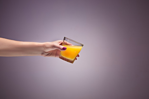 オレンジジュースを持っている女性の手