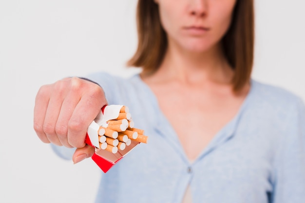 woman's hand holding packet of cigarettes