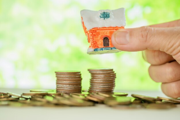 woman's hand holding small house 