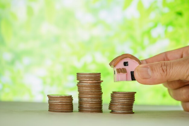 woman's hand holding small house