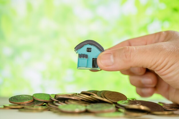 woman's hand holding small house 