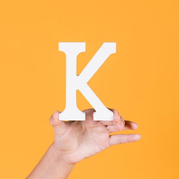 Woman's hand holding up the capital alphabet k