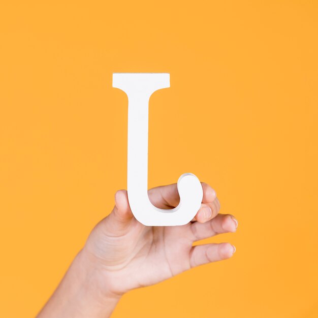 Woman's hand holding the white alphabet j