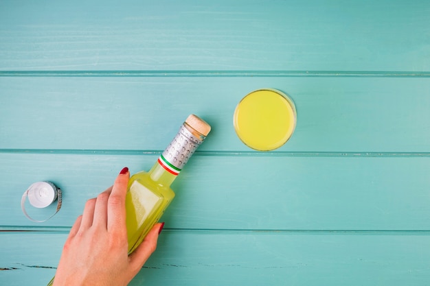 Foto gratuita la mano della donna che tiene la bottiglia di succo giallo