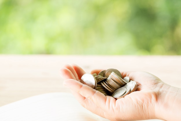 The woman's hand is holding many coins