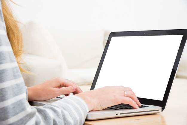 Woman's hand on laptop over the wooden table