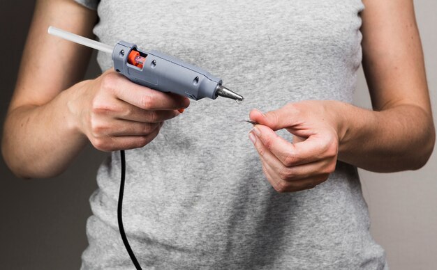 Woman's hand making craft with hot glue gun