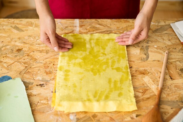 黄色の布で覆われた金型で女性の手