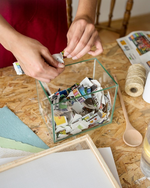 Woman's hand putting pieces of paper in container