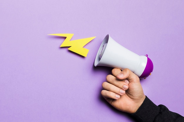 Free photo woman's hand showing power thunder with megaphone