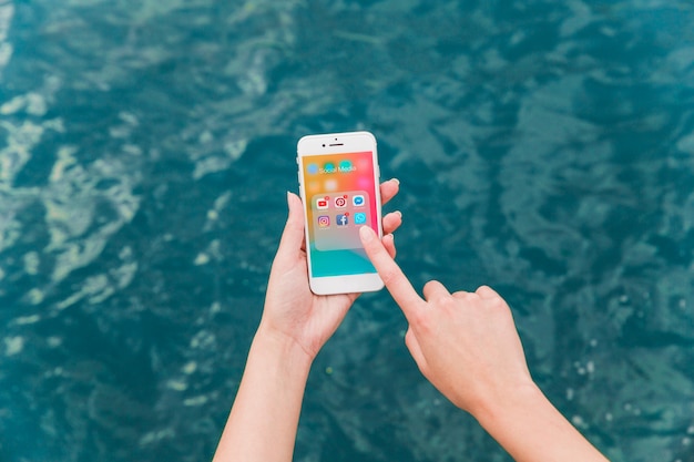 Woman's hand using cellphone with social media notifications on screen