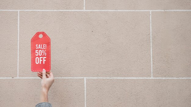 Woman's hand with red sale sign