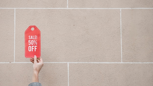 Woman's hand with red sale sign