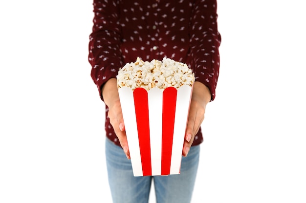 Le mani della donna che tengono secchio con popcorn su fondo bianco