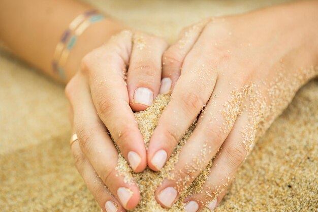 모래에 스티커 문신이 있는 여자의 손