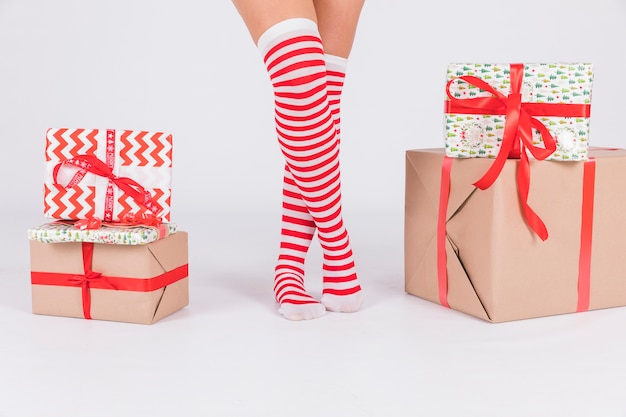 Free photo woman's legs in stockings with present boxes