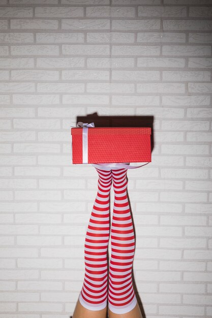 Woman's legs in stockings with red present box 