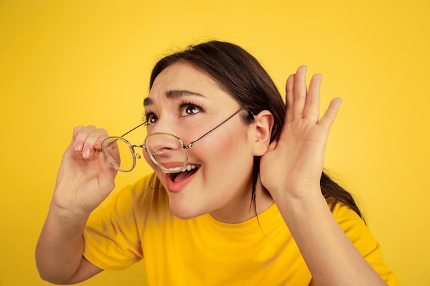 Woman's portrait isolated on yellow studio wall