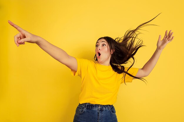 Woman's portrait isolated on yellow studio wall