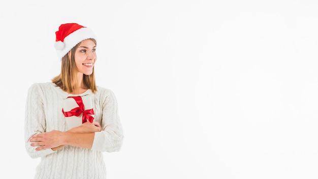 Woman in Santa hat hugging gift box 