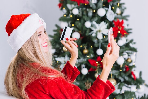 Woman in Santa hat taking selfie