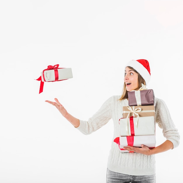 Woman in Santa hat throwing gift box