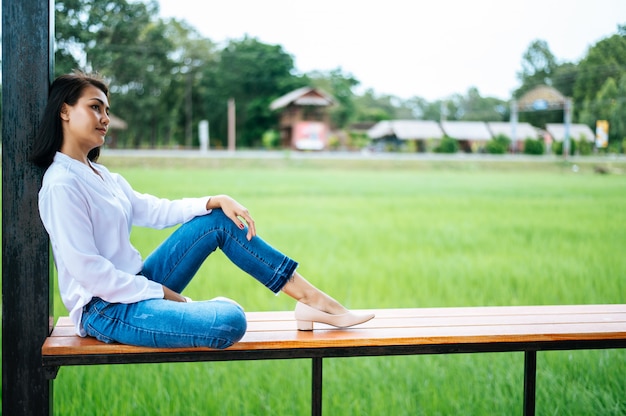 woman sat on a wooden balcony and put her hands on her knees