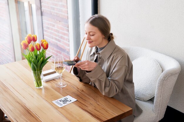 Woman scanning qr code at restaurant medium shot