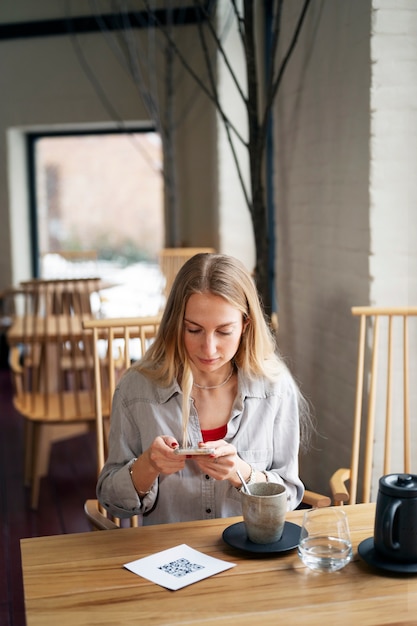 Foto gratuita donna che scansiona il codice qr al ristorante