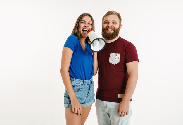 A woman screaming on a loudspeaker with a bearded man smiling by her side