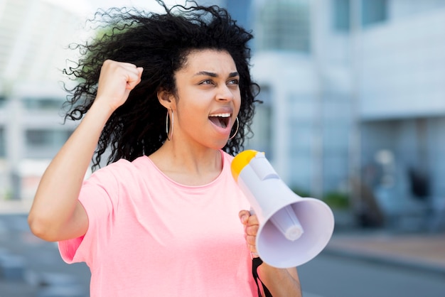 Woman screaming in megaphone side view