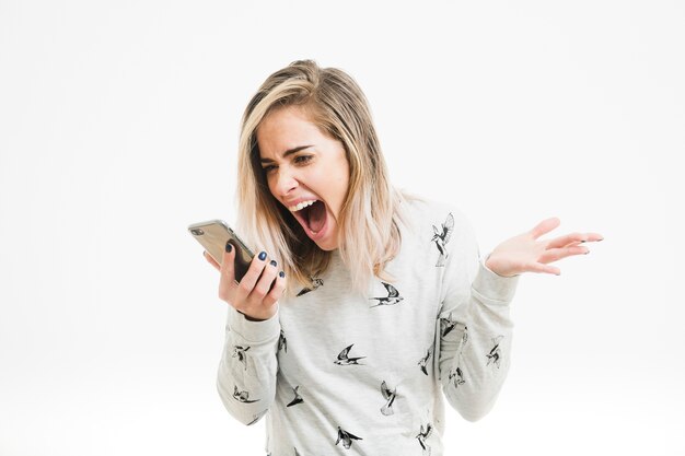 Free photo woman screaming towards smartphone