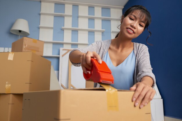 Woman Sealing Moving Box