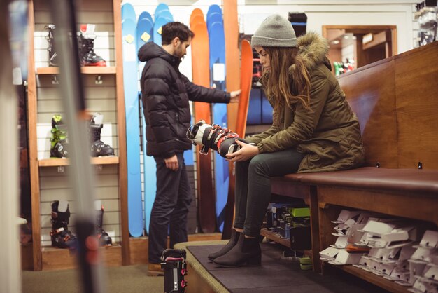 お店でスキーブーツを選ぶ女性