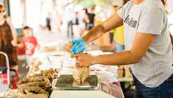 Free photo woman seller packing food for her customer in market