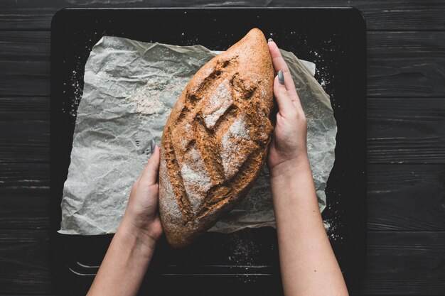 Woman serving loaf of bread