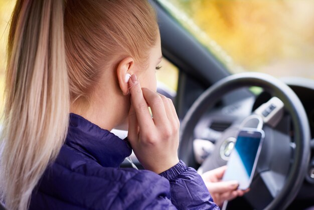 Woman settings of the phone in the car